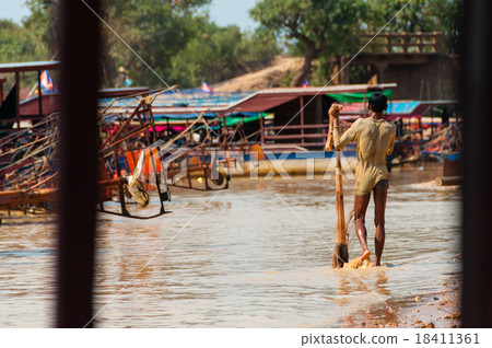 Man covered in mud with fishing net Man covered in mud with fishing net 18411361