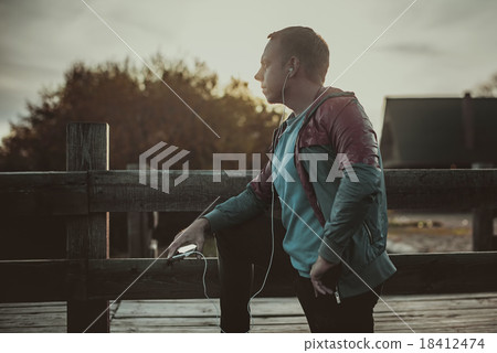 runner standing, relaxing and listening music runner standing, relaxing and listening music 18412474