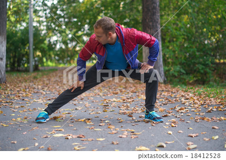 sport man stretching  autumn, doing exercises.  18412528