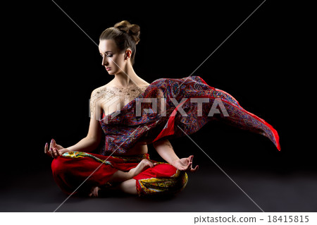 Beautiful calm woman meditates in lotus position 18415815