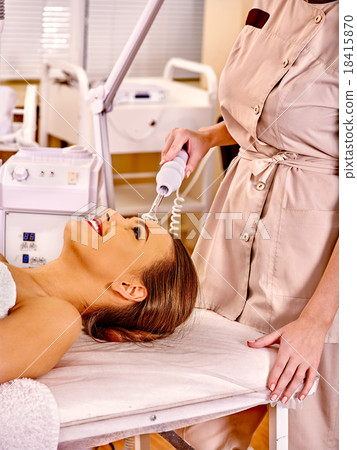 Young woman receiving darsonval electric facial 18415870