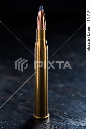Large-caliber cartridge on a dark background 18418444