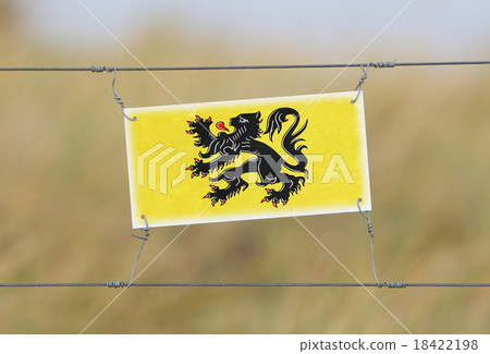 Border fence - Old plastic sign with a flag 18422198