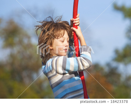 Boy on a Swing in the Playground 18423378
