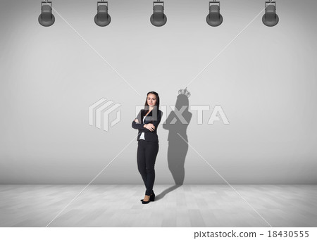 Businesswoman stands with shadow on the wall 18430555