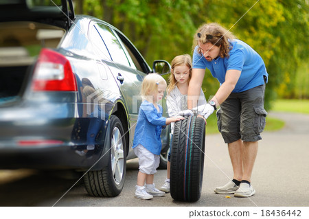 Happy family changing a car wheel 18436442