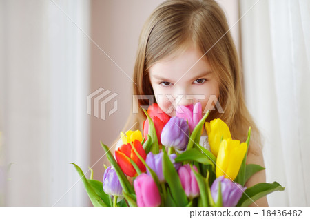 Adorable little girl holding tulips by the window 18436482