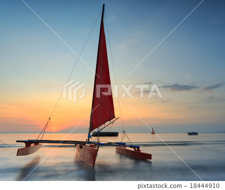 Red sailboat on the beach with a beautiful sunset Red sailboat on the beach with a beautiful sunset 18444910