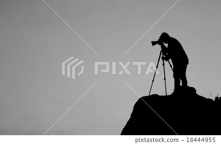 Silhouette of a photographer shooting a sunset Silhouette of a photographer shooting a sunset 18444955