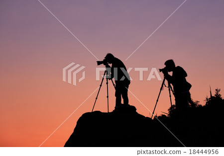 Silhouette of a photographer shooting a sunset Silhouette of a photographer shooting a sunset 18444956
