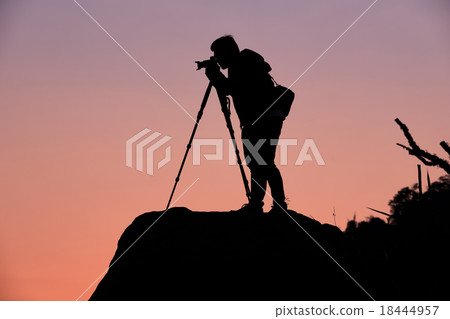 Silhouette of a photographer shooting a sunset Silhouette of a photographer shooting a sunset 18444957