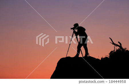 Silhouette of a photographer shooting a sunset Silhouette of a photographer shooting a sunset 18444958