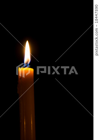Yellow candle on the dark background with bokeh 18447890
