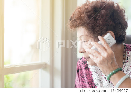 Senior woman using her smartphone to make a call  18454627
