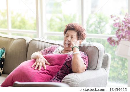 Asian senior Woman Resting on Couch with Pillow Asian senior Woman Resting on Couch with Pillow 18454635
