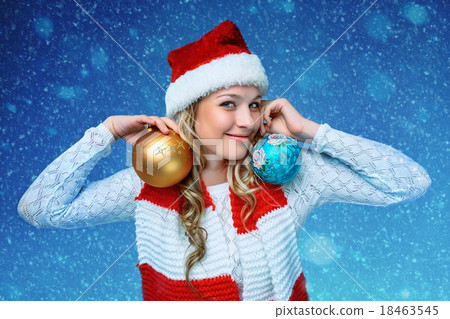 Girl dressed in santa hat holding a Christmas 18463545