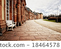 Red sandstone palace walkway with row of columns. 18464578