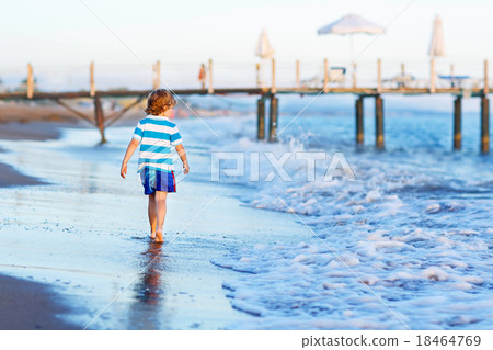 Happy little kid boy having fun with running through water in oc Happy little kid boy having fun with running through water in oc 18464769
