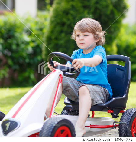 Active little boy having fun and driving toy race car Active little boy having fun and driving toy race car 18464772