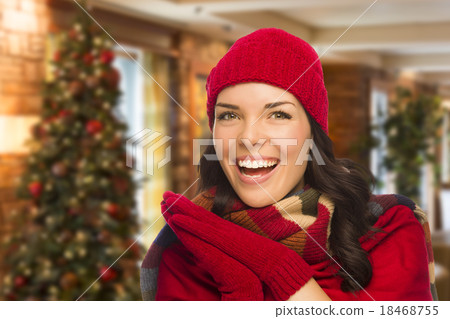 Mixed Race Woman Wearing Mittens and Hat In Christmas Setting 18468755