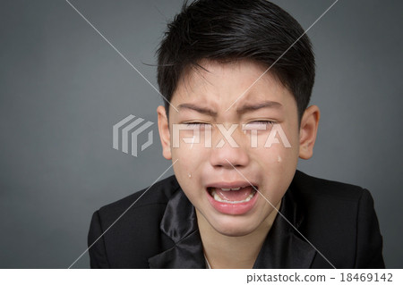 Stock Photo: Little asian boy in black suit upset, depression face