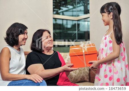 Young Asian girl offer apresent to her grandmother 18473659