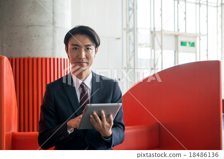 在休息室經營平板電腦的商人 18486136