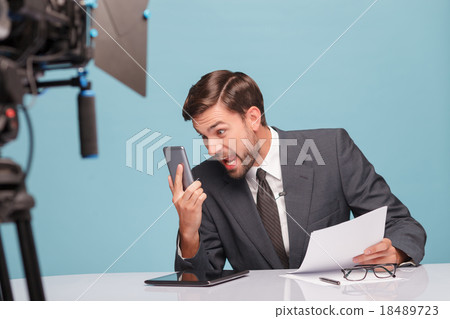 Professional male newscaster is foaming at the 18489723