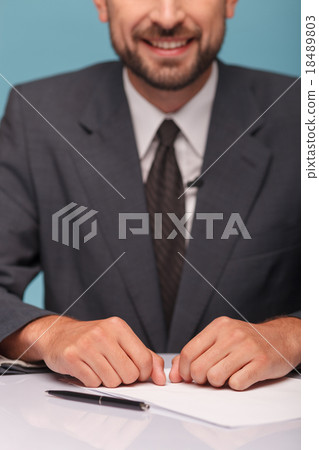 Cheerful male newscaster is making his report Cheerful male newscaster is making his report 18489803