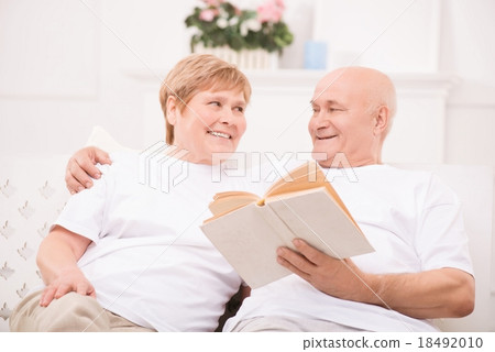 Pleasant adult couple lying on bed  18492010