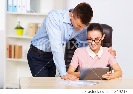 Office worker embraces his partner at the desk. Office worker embraces his partner at the desk. 18492381