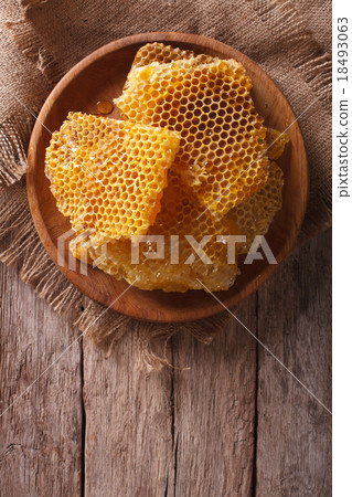 Fresh honeycombs on wooden plate vertical top view 18493063