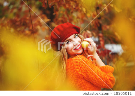 Lovely girl in beret sweater holding ripe apple 18505011