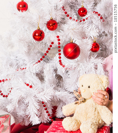 Girl Hugging Teddy Bear near christmas tree 18515756