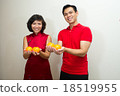 Asian couple dressed in red with oranges for CNY 18519955