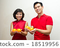 Couple offering oranges as good fortune during CNY 18519956