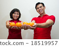 Young couple offering oranges as gold during CNY  18519957