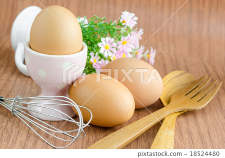 Eggs and wooden spoon with flower. 18524480