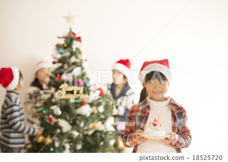 A girl with a cake in front of Christmas tree 18525720