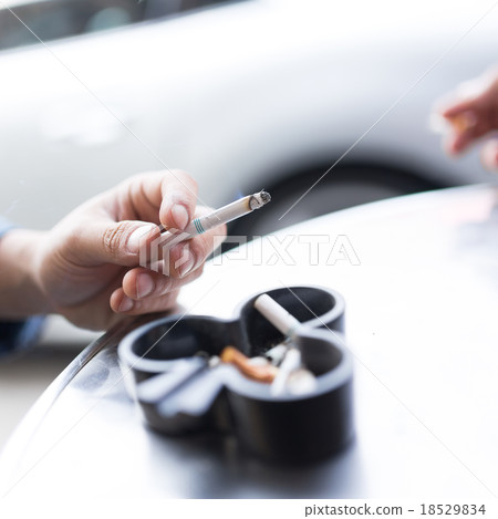 Man smoking cigarette and using an ashtray 18529834