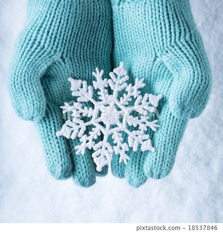 Female hands in light teal knitted mittens with 18537846
