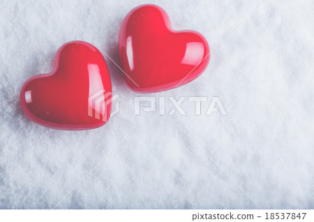 Two red glossy hearts on a frosty white snow 18537847