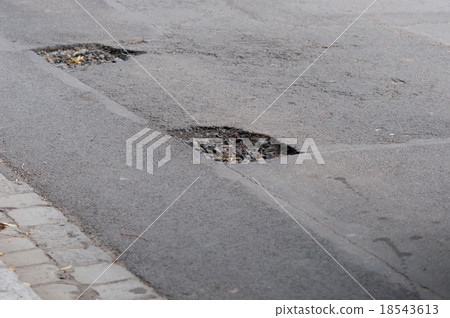 dangerous pothole on a road 18543613