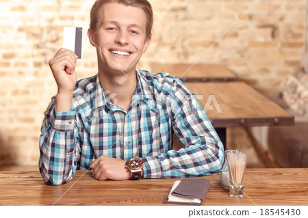 Smiling man showing his credit card  18545430
