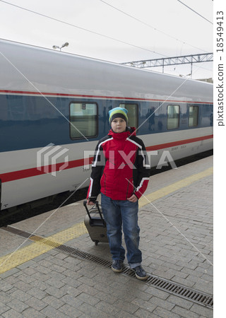 Boy teenager with  travel bag near a train 18549413