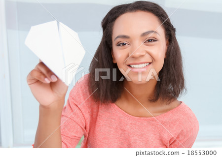 Smiling mulatto girl throwing paper plain  18553000