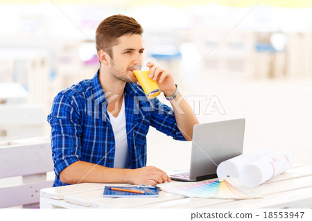 Overjoyed freelancer sitting at the table  18553947
