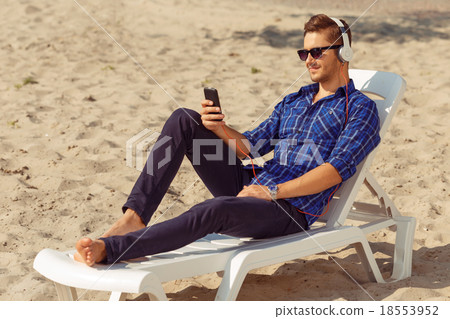 Handsome freelancer lying on the beach Handsome freelancer lying on the beach 18553952
