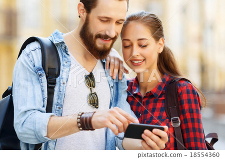 Pleasant couple holding mobile phone  18554360