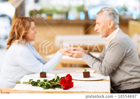 Nice adult couple sitting in the cafe Nice adult couple sitting in the cafe 18554697